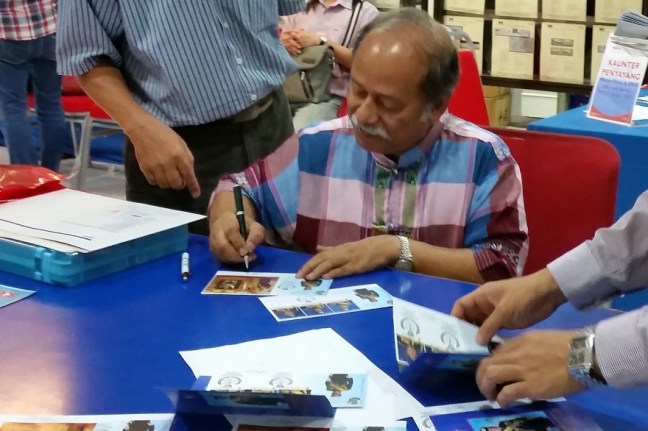 Prof Dato Raja Zahabuddin Raja Yaacob autographing Coronation Sultan Johor FDCs